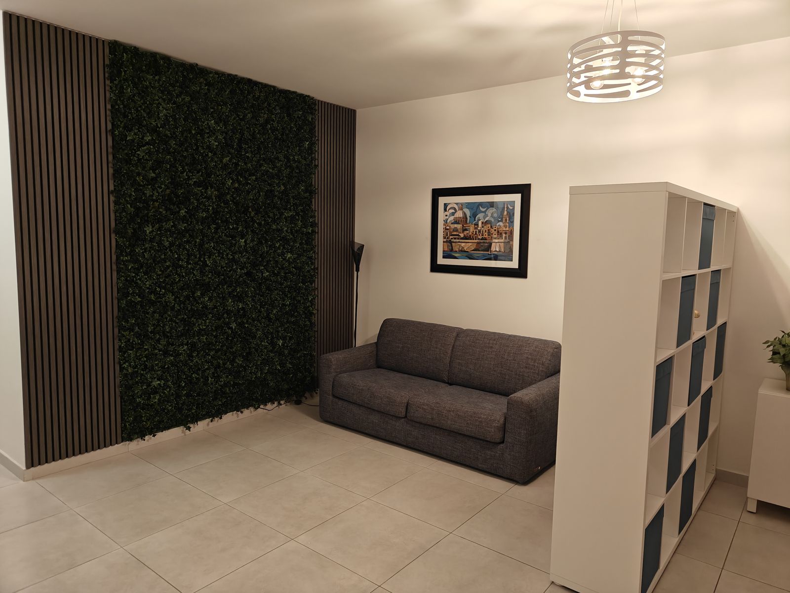 Feature wall — green foliage panel and dark wood slats behind the second sofa